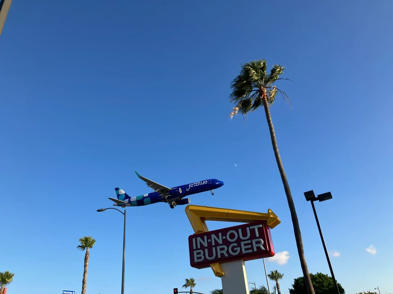 A JetBlue airliner on short final above the In-N-Out sign on Sepulveda Boulevard